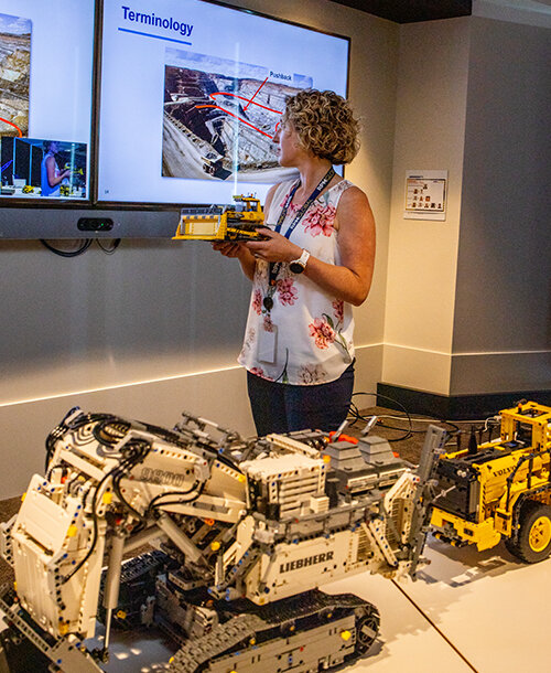 Woman presenting holding lego truck